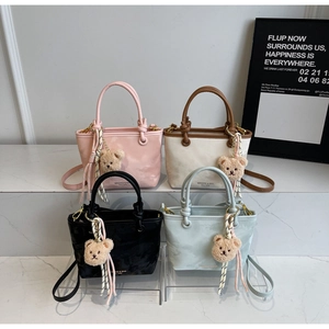 Detailed view of colorful mini tote bags in four colors with cute plush bear charms