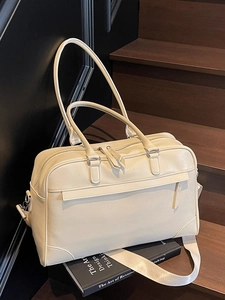 Sac de voyage Boston blanc crème avec texture cuir et bandoulière réglable sur escalier