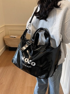Large black glossy PU travel bag with NOCO freedom print and adjustable strap