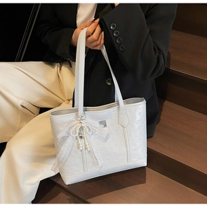 Detailed macro view of the 3D embossed floral texture on a premium white tote bag