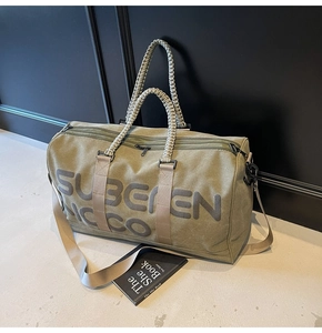 Close-up of olive green travel bag showing thick woven handles and adjustable nylon strap