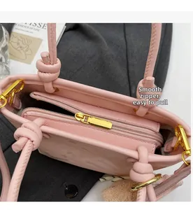 Detail of pink bucket bag featuring smooth gold-tone zipper and plush pendant