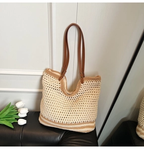 Detalle del bolso tote tejido a mano con correas de cuero marrón y remaches metálicos