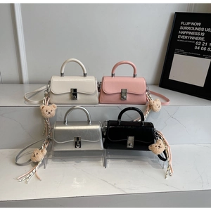 Detailed display of vintage rectangle handbags in cream, pink, silver, and black finishes