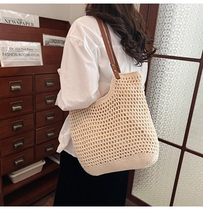 Detalle del bolso tote de ganchillo beige con asas de cuero marrón y red tejida