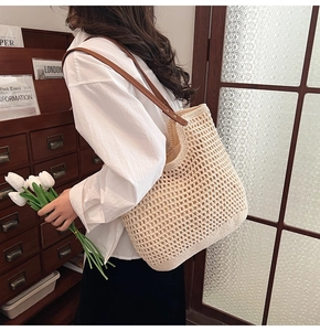 Detalle del bolso tote de ganchillo crema con correa de cuero marrón en escena retro