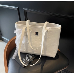 Detail of white PU leather tote bag with embossed cartoon character and lace bow