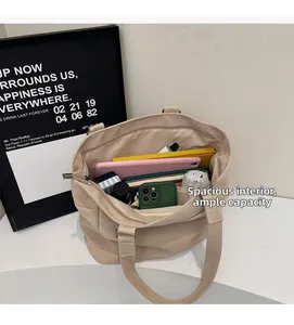 Detailed internal view of large beige canvas tote bag showing multi-pocket storage capacity