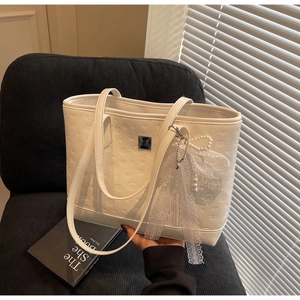 Macro view of white embossed Cinnamoroll tote bag with lace bow and pearl charm