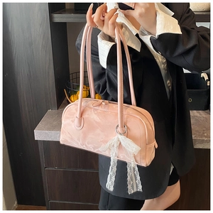 Close-up of pink marble texture Boston bag with decorative lace pearl bow charm
