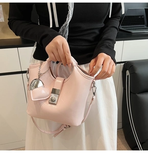 Detail view of pink glossy bucket bag with silver metal lock and heart pendant