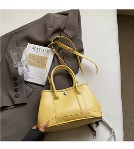 Detail der zitronengelben Eimer-Tasche aus Kieselleder mit Silberschnalle und Trageriemen