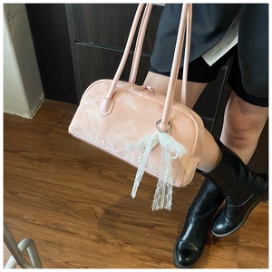 Detail of pink pillow shoulder bag with delicate white lace pearl bow pendant charm