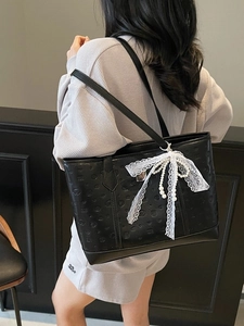 Chic black embossed tote bag with lace bow and pearl charm for casual fashion