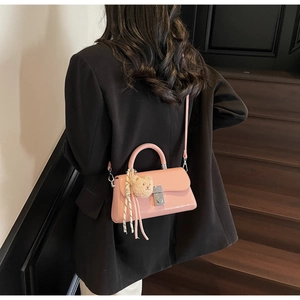 Pink patent leather mini crossbody bag featuring a cute plush bear charm detail