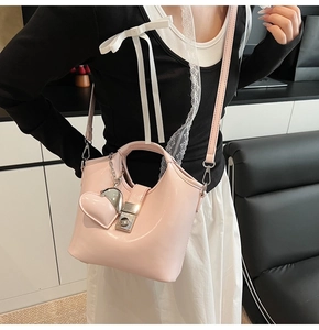 Detail of pink glossy bucket bag showing silver lock and heart shaped charm