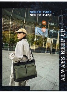 Detail of a large two-tone travel bag with dual front zipper pockets and durable straps