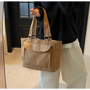 Close-up of large canvas tote bag featuring a practical front flap pocket and metal D-ring