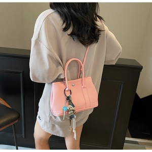 Rosa Beuteltasche aus Leder mit Narbung, Metallschnalle und süßem Hundeanhänger
