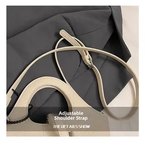 Detail view of the adjustable shoulder strap and silver buckle on a litchi grain bag