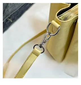 Détail du sac seau jaune avec crochets en métal argenté poli et fermeture éclair premium