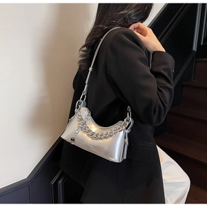 Detail of silver metallic shoulder bag with thick chain strap on fashion model