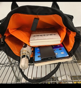 Macro view of travel bag interior showing padded laptop compartment and orange lining