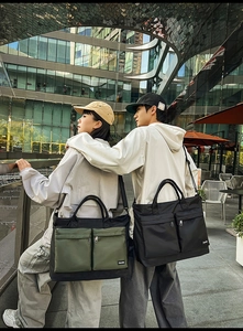 Close-up of large nylon travel tote bags with dual front pockets and waterproof texture