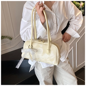 Detail of beige leather Boston bag with lace pearl bow and elegant long shoulder straps