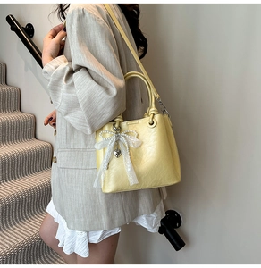 Détail du sac seau jaune avec breloque en perles et dentelle et bandoulière amovible