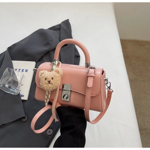 Pink PU leather handbag with silver twist lock and cute plush bear charm detail