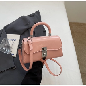 Detail of pink glossy patent leather handbag with wavy flap and silver metal lock