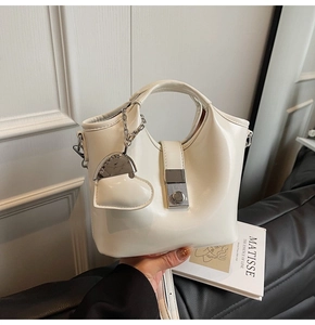 Close-up of cream-colored PU leather bucket bag with silver metal lock and heart charm