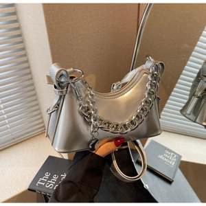 Detail of silver metallic crescent bag with chunky chain strap and logo branding