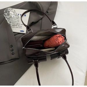 Interior view of the dark brown glossy pillow bag showing ample storage for daily essentials