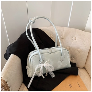 Detail of light blue pillow bag with elegant white lace bow and pearl pendant decoration
