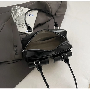 Detail view of the black pillow bag interior with smooth leather texture and zipper closure