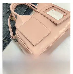 Close-up of pink glossy pillow bag featuring transparent card slot and silver D-rings