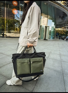 Detail view of large travel bag showing dual front zip pockets and waterproof nylon texture