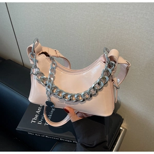 Detail of light pink patent leather shoulder bag with glossy finish and silver chain