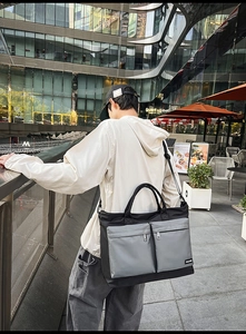 Outdoor shot of the large capacity grey-black travel bag showing side view on shoulder