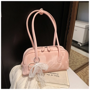 Detail of pink Boston bag with elegant lace bow, pearl pendant and long handles