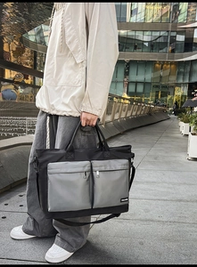 Detail of waterproof travel bag with two front zipper pockets and detachable strap