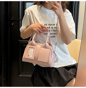 Dettaglio della borsa a cuscino rosa lucido con doppi manici e scomparto per carte trasparente
