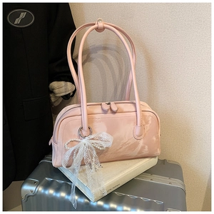 Detail of pink faux leather shoulder bag with white lace bow and pearl chain charm