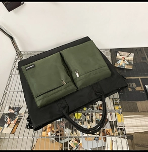 Detail of waterproof nylon travel bag with dual olive green zippered pockets and webbed handles