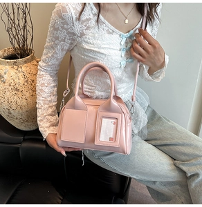 Dettaglio borsa a bauletto in pelle verniciata rosa con doppie tasche frontali e fessura per carte