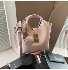 Detail of pink PU tote bag featuring a metal buckle closure and heart-shaped pendant