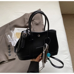 Detail der schwarzen Bucket-Bag aus strukturiertem Leder mit silbernen Metallteilen