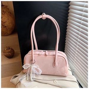 Pink patent leather shoulder bag detail with pearl lace bow and embossed logo